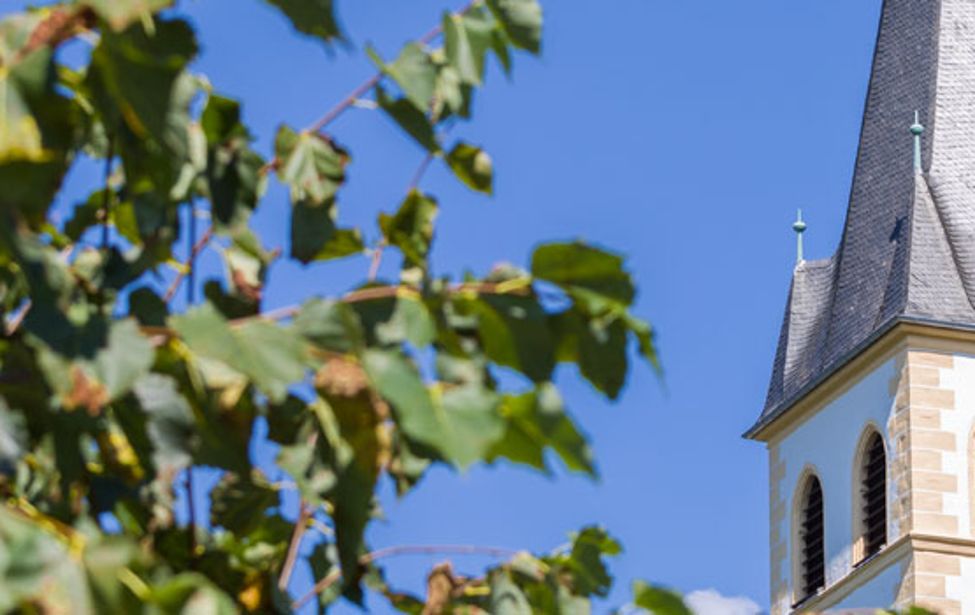 Detail eines Kirchturms vor blauem Himmel